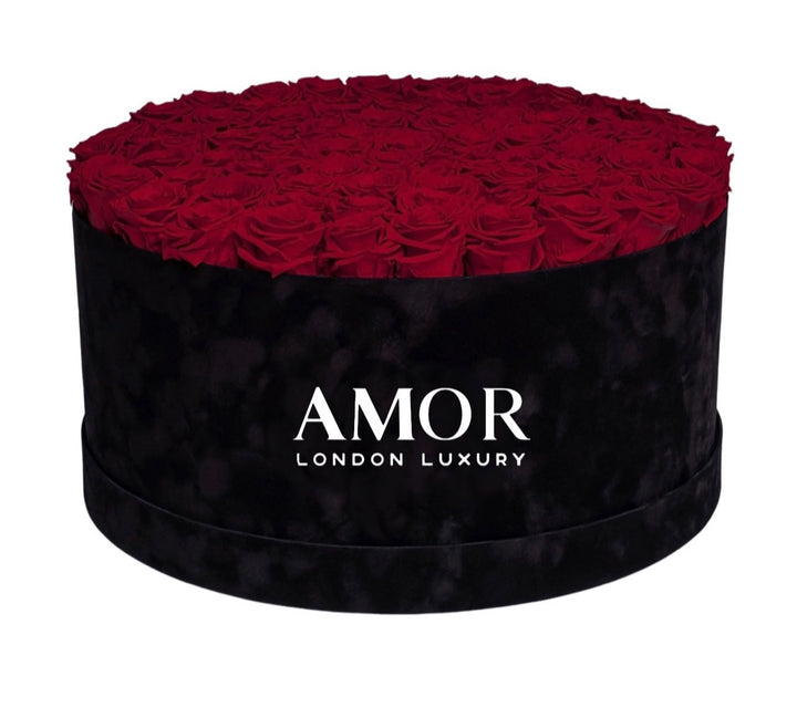 85-100 roses in a deluxe round black suede box.