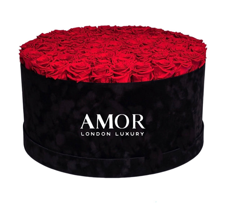 85-100 roses in a deluxe round black suede box.